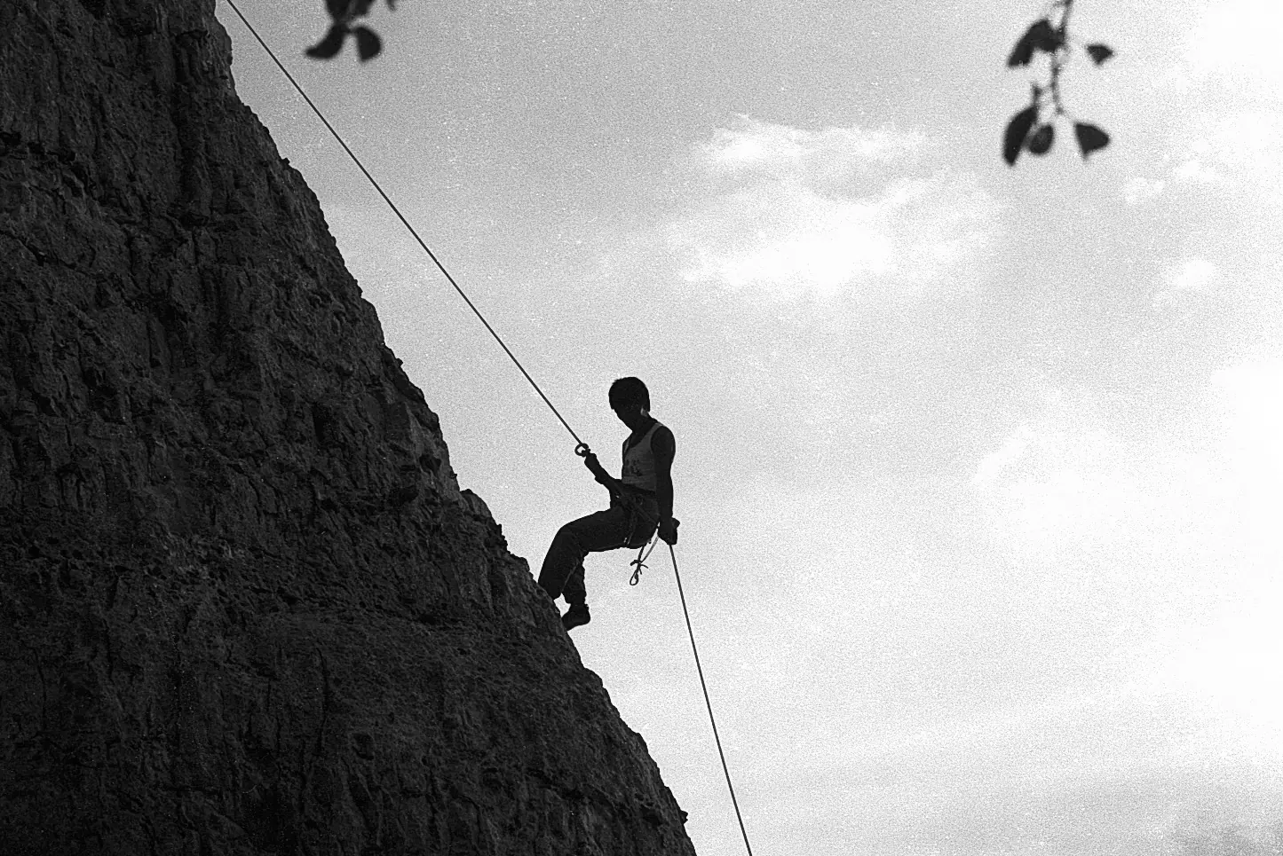 Alpiniste en rappel sur corde, falaises de la Seine près des Andelys, Eure — argentique noir et blanc, 1990
