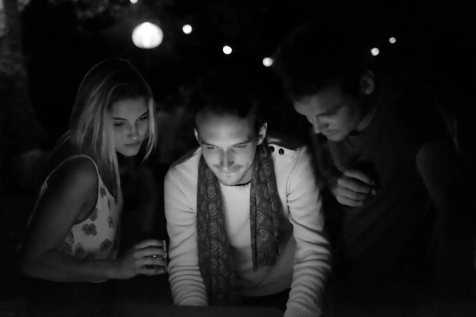 Trois amis souriants éclairés à la bougie pendant une fête d'anniversaire, Villeneuve d'Aveyron — août 2011